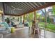 Stylish outdoor patio featuring comfortable seating, a barrel table, and a hot tub in the background at 6480 Moss Cir, Arvada, CO 80007