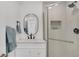 Bright bathroom features a shower with glass door, modern fixtures and an oval mirror at 7826 Joan Dr, Denver, CO 80221