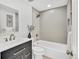 Updated bathroom with dark vanity, tub, and gray herringbone tile shower surround at 7826 Joan Dr, Denver, CO 80221