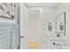 Bright bathroom features a white vanity, a wood trimmed mirror, and modern fixtures at 7826 Joan Dr, Denver, CO 80221