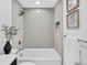 Modern bathroom with shower over tub, neutral tile, and decorative wall art at 7826 Joan Dr, Denver, CO 80221