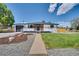 Well-maintained home with inviting front porch, landscaped yard, and mature trees at 7826 Joan Dr, Denver, CO 80221