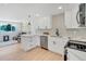 Open concept kitchen with stainless steel appliances, white cabinets, and view of living room at 7826 Joan Dr, Denver, CO 80221