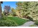 Scenic backyard view featuring lush green lawn, colorful flowers, and surrounding trees at 24273 E Fremont Dr, Aurora, CO 80016