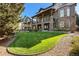 Well maintained backyard with healthy green lawn, stone facade, and covered balconies at 24273 E Fremont Dr, Aurora, CO 80016
