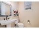 Charming powder room with a rustic mirror, pedestal sink, and decorative towel rack at 24273 E Fremont Dr, Aurora, CO 80016