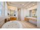 Luxurious bathroom boasts a large tub, dual vanity areas, ample mirrors, and modern lighting at 24273 E Fremont Dr, Aurora, CO 80016