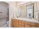 Light bathroom with double sink, wooden cabinets, and bathtub with shower at 24273 E Fremont Dr, Aurora, CO 80016