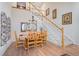 Open-concept dining room with hardwood floors, a staircase and a decorative light fixture above the dining table at 24273 E Fremont Dr, Aurora, CO 80016