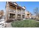 Beautiful exterior view of a multi-story home with a stone facade, covered balconies, and landscaped lawn at 24273 E Fremont Dr, Aurora, CO 80016