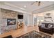 Open concept living room with stone fireplace, hardwood floors, and seamless flow into the kitchen area at 24273 E Fremont Dr, Aurora, CO 80016