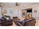 Cozy living room featuring hardwood floors, a stone fireplace, and comfortable leather seating at 24273 E Fremont Dr, Aurora, CO 80016