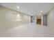 Finished basement area with tile flooring, recessed lighting, and access to stairs at 6393 S Richfield St, Aurora, CO 80016