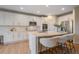 Gourmet kitchen featuring white cabinets, quartz countertops, stainless steel appliances, and breakfast bar at 6393 S Richfield St, Aurora, CO 80016