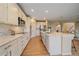 Spacious kitchen with white cabinets, quartz countertops, stainless steel appliances, and center island at 6393 S Richfield St, Aurora, CO 80016
