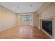 Bright living room featuring hardwood floors, bay window, fireplace, and built-in shelving at 6393 S Richfield St, Aurora, CO 80016