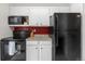 This compact kitchen is equipped with black appliances, white cabinets, and granite countertops at 8738 Chase Dr # 133, Arvada, CO 80003