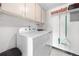 A clean laundry room features a washer, dryer, and storage shelves at 8738 Chase Dr # 133, Arvada, CO 80003