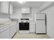 Compact kitchen featuring white cabinets, white appliances, and tile flooring at 7900 W Layton Ave # 864, Littleton, CO 80123