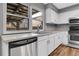 Bright kitchen features white cabinetry, modern appliances, and a window overlooking a backyard structure at 7900 W Layton Ave # 864, Littleton, CO 80123