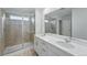 Modern bathroom features glass shower and a dual sink vanity with a large mirror at 8840 Whiteclover St, Littleton, CO 80125