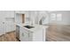 Bright kitchen island with stainless dishwasher, sink, and white countertops, with hardwood floors at 8840 Whiteclover St, Littleton, CO 80125