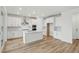 Modern kitchen features white cabinets, stainless steel appliances, hardwood floors, and a stylish center island at 8840 Whiteclover St, Littleton, CO 80125