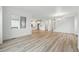 Bright living room with hardwood floors and natural light, with an open floor plan leading into kitchen and stairs at 8840 Whiteclover St, Littleton, CO 80125