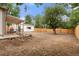 Large fenced backyard with a wood fence, big mature tree, stone landscaping feature, and covered deck area at 3287 S Humboldt St, Englewood, CO 80113
