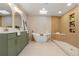 Stunning bathroom features a soaking tub, walk-in shower, olive green double vanity, and modern fixtures at 3287 S Humboldt St, Englewood, CO 80113