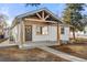 Inviting home featuring a stylish front porch with modern wooden support beams and neutral color palette at 3287 S Humboldt St, Englewood, CO 80113