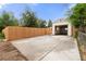 Detached garage features a spacious concrete parking pad, a wooden privacy fence, and a garage door at 3287 S Humboldt St, Englewood, CO 80113