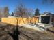 A fenced backyard that features a detached one car garage with a paved driveway for extra parking at 3287 S Humboldt St, Englewood, CO 80113