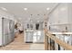 Kitchen with stainless steel appliances, white cabinets, breakfast bar, and open access to living area at 3287 S Humboldt St, Englewood, CO 80113