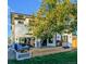 The backyard features a wooden deck with outdoor seating, mature trees and a well-kept lawn at 2182 S Ogden St, Denver, CO 80210