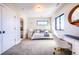This carpeted bedroom includes a bed, desk, and natural light from the large window at 2182 S Ogden St, Denver, CO 80210