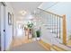 Inviting foyer with hardwood floors, staircase with black iron railing, and view into the home's open floorplan at 2182 S Ogden St, Denver, CO 80210