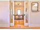 Home office featuring hardwood floors, neutral paint, statement mirror, and sliding doors for privacy at 2182 S Ogden St, Denver, CO 80210
