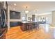 Open kitchen features stainless appliances, dark cabinets, large island with seating, and hardwood floors at 2182 S Ogden St, Denver, CO 80210