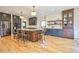 Bright kitchen features stainless appliances, dark cabinets, large island with seating, and hardwood floors at 2182 S Ogden St, Denver, CO 80210