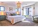 Spacious main bedroom boasts a decorative chandelier, large windows, and soft, natural lighting at 2182 S Ogden St, Denver, CO 80210