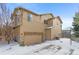 Two-story home with attached garage and snowy driveway at 3953 Blue Pine Cir, Highlands Ranch, CO 80126