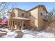 Two-story tan house with snow-covered walkway and landscaping at 3953 Blue Pine Cir, Highlands Ranch, CO 80126