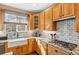 Kitchen with white farmhouse sink, granite countertops, and wood cabinets at 3953 Blue Pine Cir, Highlands Ranch, CO 80126