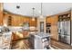 Open kitchen with large island, stainless steel appliances, and wood cabinets at 3953 Blue Pine Cir, Highlands Ranch, CO 80126