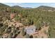 Aerial view of home nestled among lush greenery with expansive mountain and forest views in the background at 6904 Sprucedale Pkwy, Evergreen, CO 80439