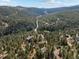 Gorgeous aerial view of homes nestled in a mountain forest at 6904 Sprucedale Pkwy, Evergreen, CO 80439