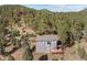 Aerial view of home surrounded by lush greenery and trees, showcasing the surrounding scenic beauty and landscape at 6904 Sprucedale Pkwy, Evergreen, CO 80439