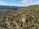 Aerial view of a home in the mountains nestled in a lush forest at 6904 Sprucedale Pkwy, Evergreen, CO 80439