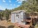 Home exterior showcasing multiple decks surrounded by trees and blue sky at 6904 Sprucedale Pkwy, Evergreen, CO 80439
